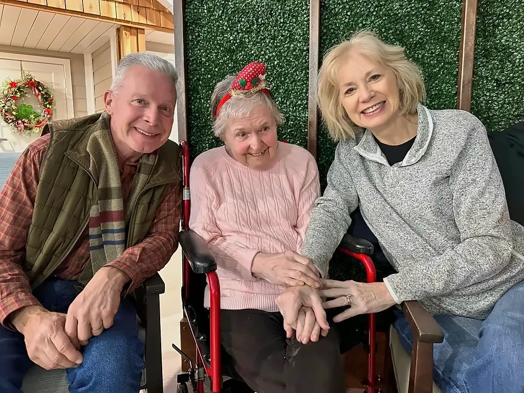 A memory care resident with two visiting family members.