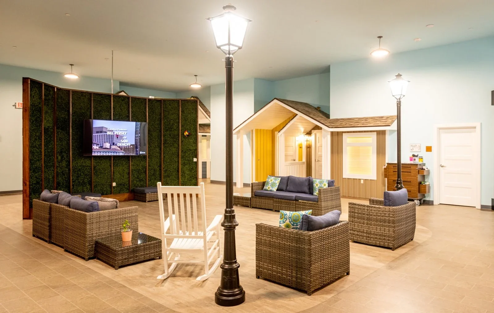 Memory care common area with seating and house-style facades